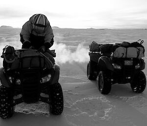 Expeditioner sitting on a quad bike on the sea ice.