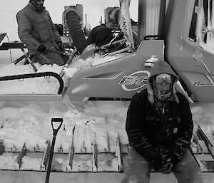 Two expeditioners beside a groomer during recovery activities