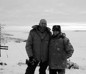 Two expeditioners facing camera with sea ice in background
