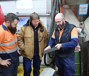 Three expeditioners facing camera holding an ipad whilst conducting an electronic audit
