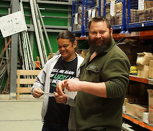 Two expeditioners reading their scripts smiling.