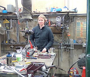 Expeditioner inside a welding bay facing camera