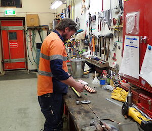 Expeditioner standing by workbench