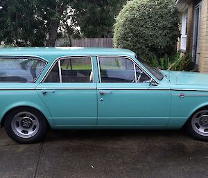 Side on photo of an aqua-marine valiant wagon parked in a driveway