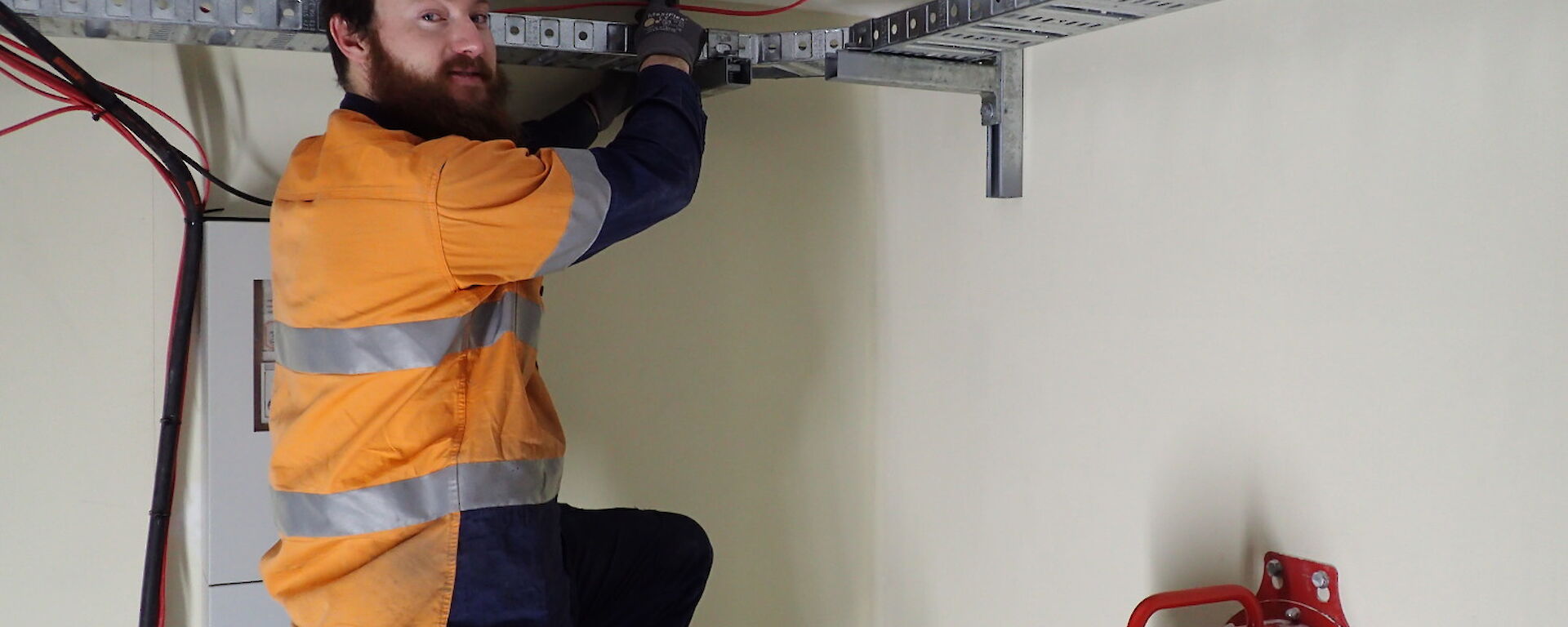 Expeditioner standing on a ladder inside a ring main unit