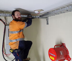 Expeditioner standing on a ladder inside a ring main unit