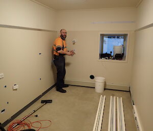 Expeditioner standing in a vacant room with wiring