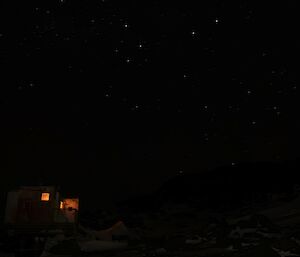 Hut in the darkness with lights on inside