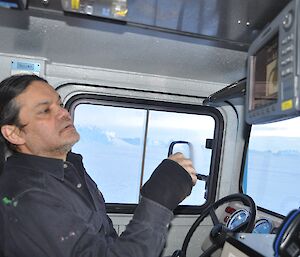 Expeditioner inside the cabin of a Hägglunds tracked vehicle