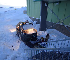Exacavator used for dumping snow inside outside spa