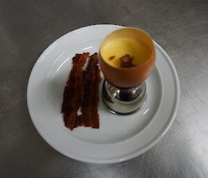 Egg custard with bacon crisps and truffle oil on a plate
