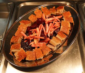 Confit crispy skinned pork belly served with an apple and a baby beetroot celery