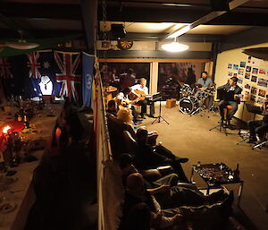 birdseye view of a makeshift divider between abandoned dining room and a music room filled with a band and expeditioners seated