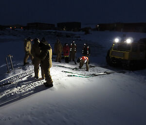Expeditioners undertaking Hagg recovery training, with vehicle illuminating the activity.