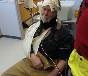 Expeditioner sitting in the medical quarters with bandaged head