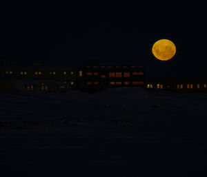 low exposure photograph of moon rising low above Davis station