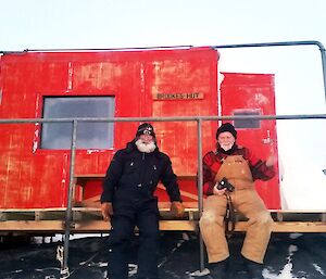 Two expeditioners sitting outside Brookes hut