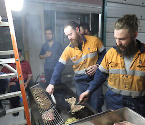 Two expeditioners cooking meat on the barbecue