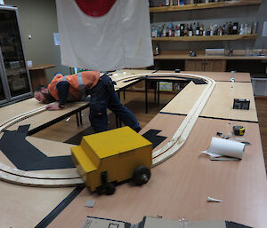 Expeditioner working on a model train track.