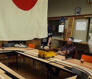 Model train driving around a table with a platter of sushi on its top