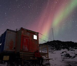 Expeditioner sitting on bench in front of Platcha hut