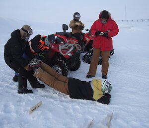 Expeditioner being dragged by his legs off the track, other expeditioners writing in notebooks above him