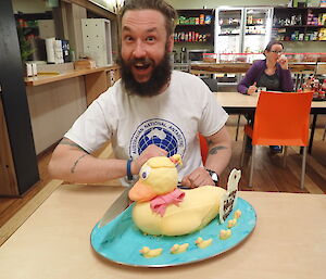 Expeditioner posing behind his birthday cake shaped like a duck