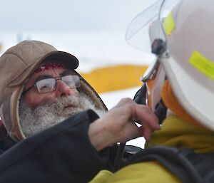 Expeditioner in fire fighting kit assisted by a colleague