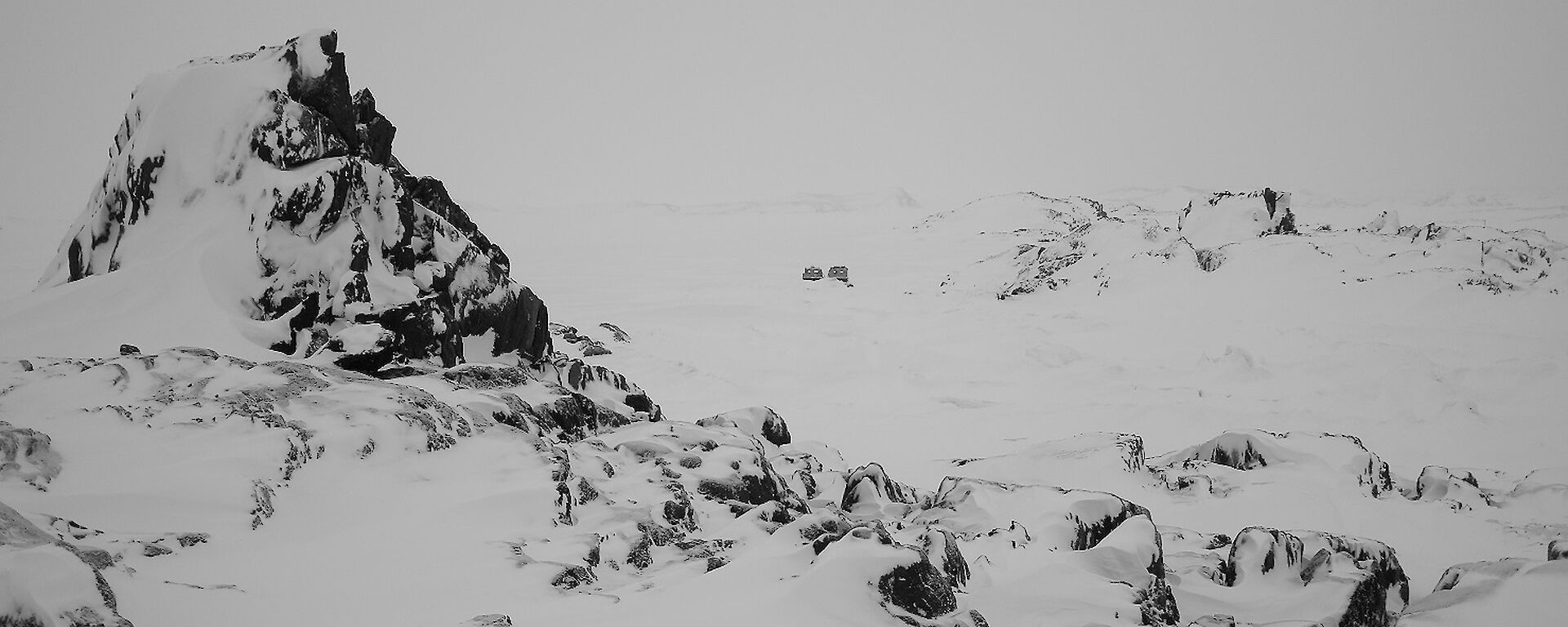 Rocky outcrop on Kazak Island with tracked vehicle in background