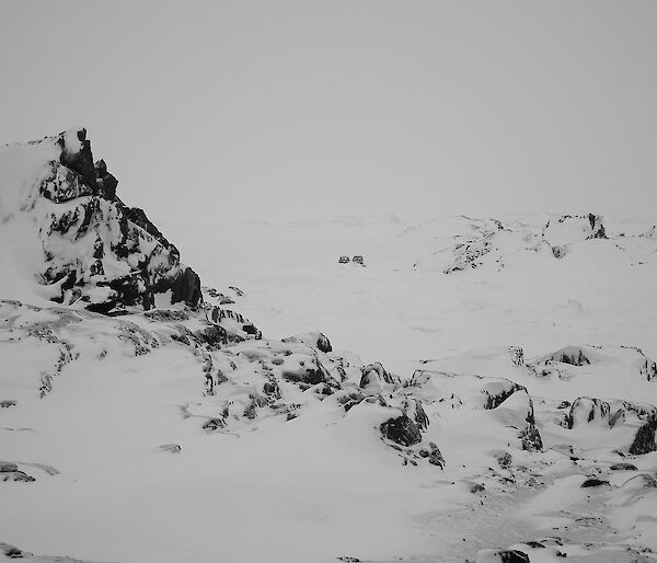 Rocky outcrop on Kazak Island with tracked vehicle in background