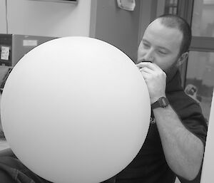 Expeditioner attempting to blow up a weather balloon