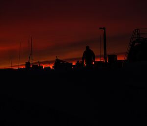 Expeditioner silhouetted against pre-dawn sky on his way back to the workshop