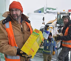 Expeditioners form a human chain to transport food inside.