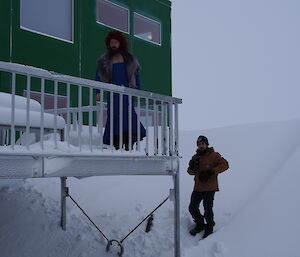 A male expeditioner in a dress standing on the balcony of the living quarters, ready to do a scene from the film ‘Titanic'.