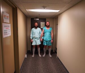 Two male expeditioners in dresses and holding hands re-enacting a scene from the film, ‘The Shining'