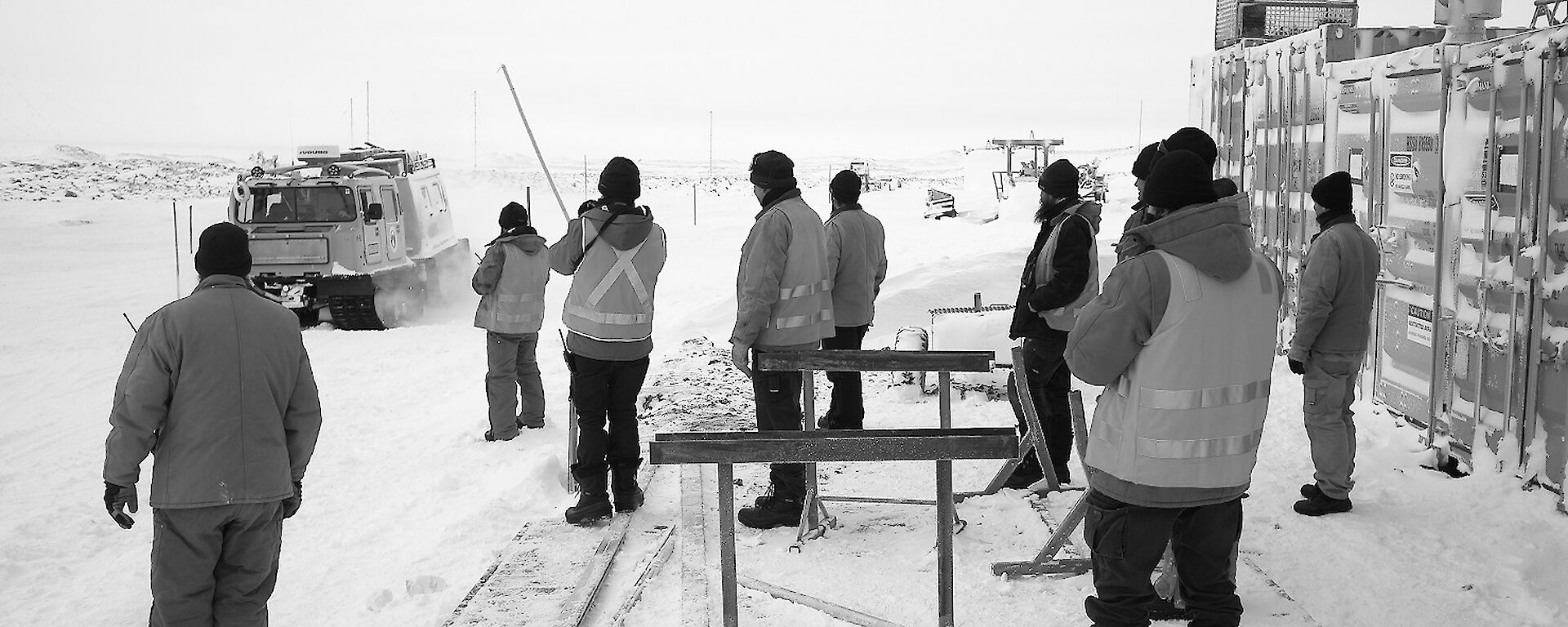 The crowd observe a Hägglunds tracked vehicle steering around canes.
