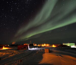 Green aurora sweeping across the night sky above the station.