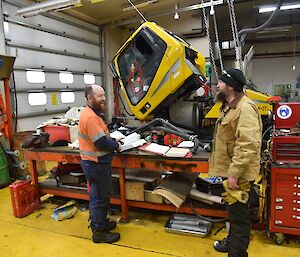 Expeditioners laughing in the workshop with a groomer in background.