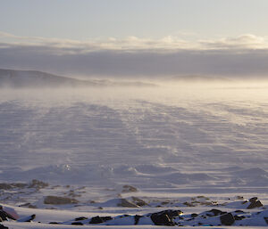 Wind whipping up snow on the sea ice in front of the station.