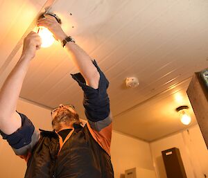 Expeditioner changing a light bulb.