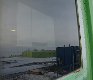 External shot of a window with station reflected in it and a satellite device positioned inside