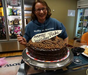 Expeditioner smiling behind a birthday cake