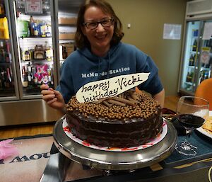 Expeditioner smiling behind a birthday cake