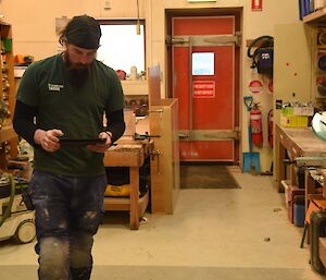 Expeditioner standing beside a workbench with an ipad