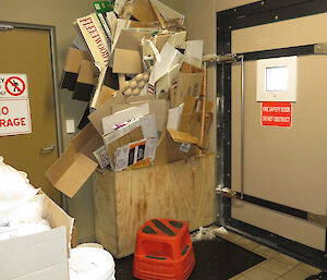 A pile of cardboard boxes sit stacked in a corner of the kitchen