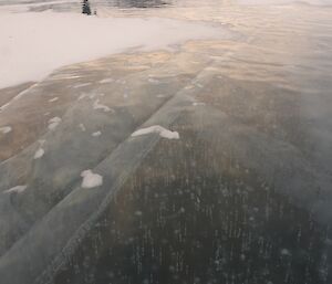 Frozen sea ice in foreground with expeditioner walking atop it in background