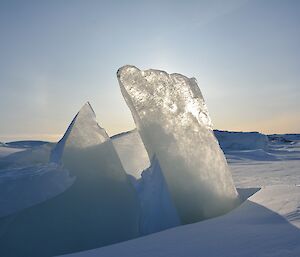 A sharp square blade of ice rising from a frozen fjord