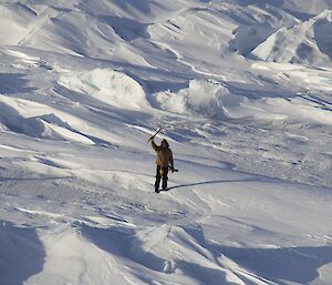 Expeditioner standing on frozen ice facing camera from a distance