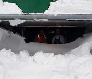 Expeditioners standing in an entrance way covered in snow