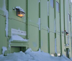 Doorway and windows almost fully concealed by snow